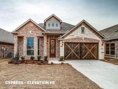 a brick and stone house with two garages