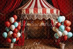 a circus tent with red, white and blue balloons