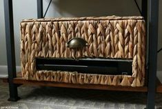 a wicker basket on top of a wooden table with a metal object in it