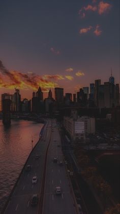 an aerial view of a city at sunset with cars driving on the road and buildings in the background