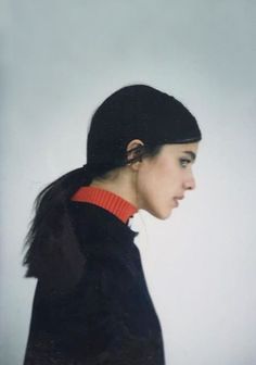 a woman wearing a black coat and red collar