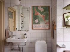 a bathroom with a toilet, sink and mirror in it's corner next to a urinal