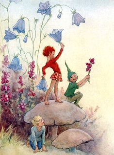 two children are playing on a rock with flowers in the foreground and one child is holding a flower