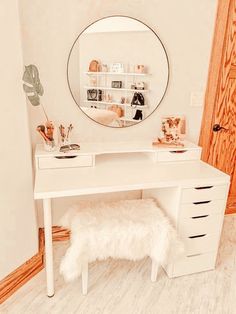 a white desk with a mirror on it and a bench in the corner next to it