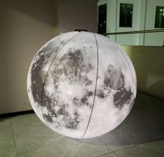 a large white ball sitting on top of a tiled floor