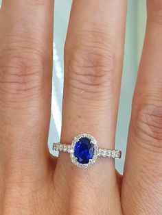 a woman's hand with a ring on it and a blue stone in the middle