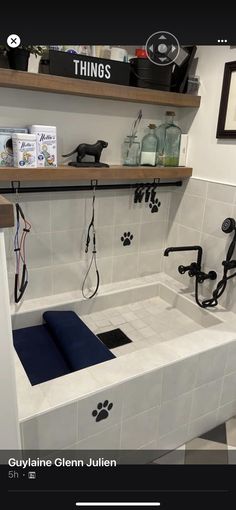 a dog's paw prints are on the wall in this bathroom with white tile