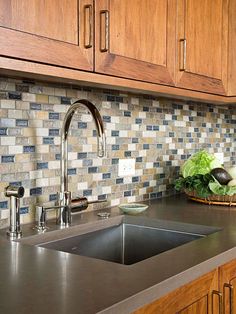 a kitchen sink and counter top with wooden cabinets in the backround, next to a bowl of lettuce