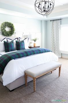 a large bed sitting in a bedroom next to a window with a wreath on it