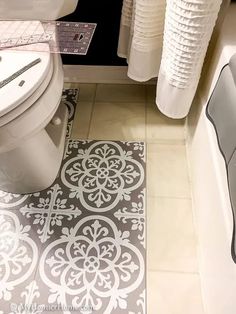 a white toilet sitting next to a bath tub in a bathroom on top of a tiled floor