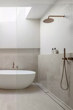 a white bath tub sitting next to a shower in a bathroom under a skylight