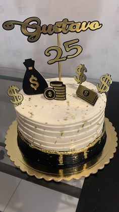 a white cake with gold lettering and money signs on top is sitting on a table