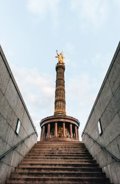 an upward view of the steps leading up to a golden statue