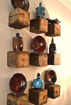 several pieces of wood are arranged on the wall with bowls and vases in them