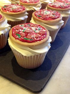 cupcakes with white frosting and sprinkles are on a tray