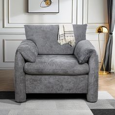 a grey couch sitting on top of a rug in a living room