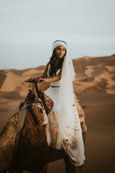 a woman riding on the back of a camel