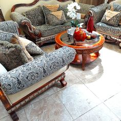 a living room filled with lots of couches and chairs next to each other on top of a tile floor