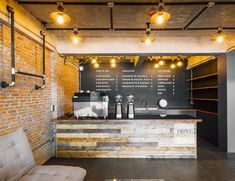 the interior of a coffee shop with brick walls and exposed ceilinging, lights on