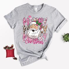 "Tired of classic Christmas shirts? Stand out with our Santa Claus t-shirt featuring leopard details and pink highlights--perfect for showcasing your personality! Hey there, style icon! These shirts are special pieces that fill me with joy and excitement while designing them just for you. Each one is carefully created to add a touch of happiness to your day and become your wardrobe favorite. Whether you're treating yourself or looking for a sweet gift for someone you love, these soft and high-qu Retro Christmas Shirt, Santa Tee, Pink Santa, Santa Shirt, Pink Highlights, Santa Shirts, Merry Christmas Santa, Merry Christmas Shirts, Pink Leopard