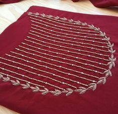 a close up of a red cloth with beads on it