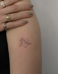 a woman's arm with a small tattoo on the left side of her arm