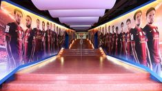 the hallway is lined with posters and steps leading up to an indoor soccer game area