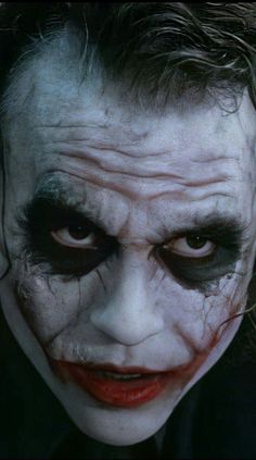 a close up of a person with makeup on and his face painted like the joker