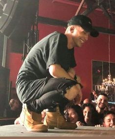 a man sitting on top of a table next to a group of people