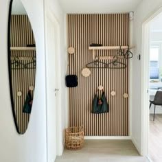 the hallway is decorated with black and white striped wallpaper, coat racks and hooks