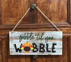 a wooden sign that says gobble til you wobble hanging on a door handle