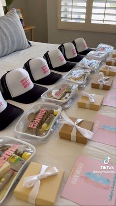 many hats are lined up on a table with food in containers next to each other