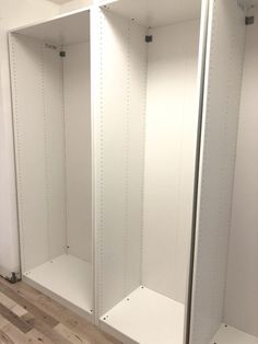 three empty white closets in a room with hard wood flooring