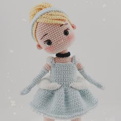 a crocheted doll is wearing a blue dress