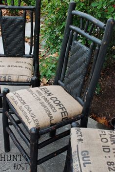 two black chairs with burlocks on them sitting next to each other in front of some bushes