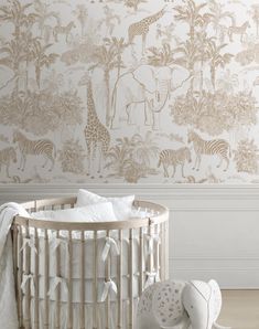 a baby crib in front of a wall with zebras and giraffes on it