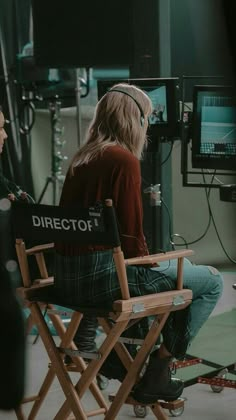 a person sitting in a director's chair watching television