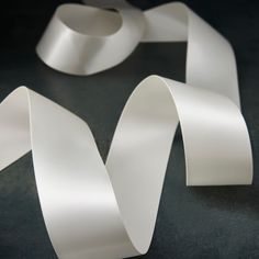 three white ribbons on a black surface