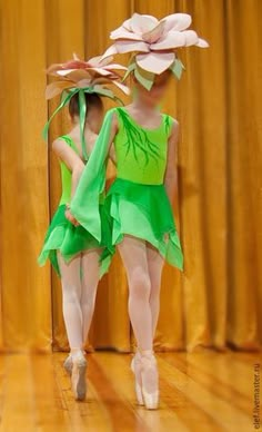 two women in green dresses are dancing on the stage