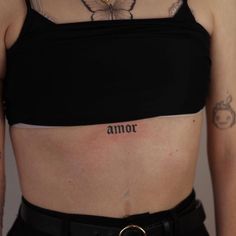 a woman with a butterfly tattoo on her chest and the word armor written in cursive writing