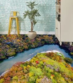 the floor is covered in colorful trees and water, while a ladder stands above it