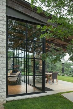 an open patio with glass walls and sliding doors leading to the outside dining room area