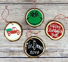 three christmas ornaments are hanging on a wooden table