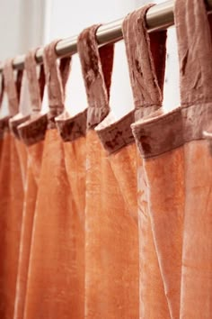 an orange curtain hanging from a metal rod