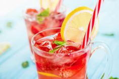 two glasses filled with watermelon and lemonade on top of a blue table