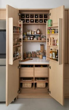 an open pantry with lots of food and spices in the cupboards next to it