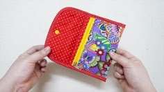 two hands are holding an empty wallet on a white surface with polka dots and flowers