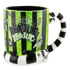 a green and black striped coffee mug with the words beetlejuice on it's side