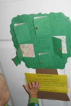 a child holding up a piece of paper cut out of a tree