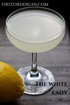 the white lady cocktail is served in a coupe glass with a lemon next to it